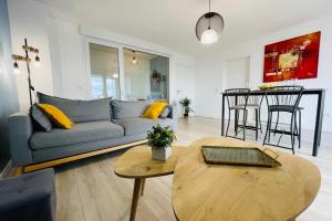 a living room with a couch and a table at Bright apartment in a new building with garage in Tours