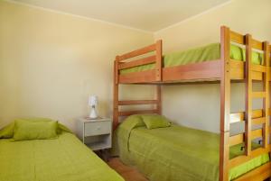 two bunk beds in a room with green sheets at Moderna Casa Nueva - Bahía Inglesa in Bahia Inglesa