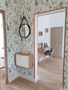 een woonkamer met een spiegel en een tafel bij Les Marguerites, maison proche de Chambord in Bracieux