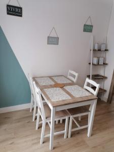 einen weißen Tisch und Stühle im Esszimmer in der Unterkunft Les Marguerites, maison proche de Chambord in Bracieux