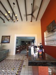 a kitchen and dining room with red and yellow walls at Hotel Las Monjas in M&eacute;rida