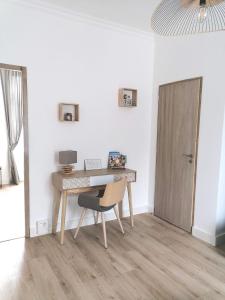 een bureau in een kamer met een stoel en een deur bij Les Marguerites, maison proche de Chambord in Bracieux
