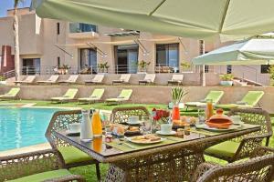 a table with food on it next to a pool at Villa Selma avec piscine chauffée in Marrakesh