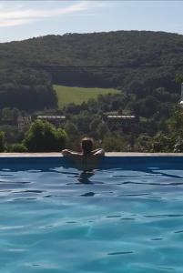 a woman in the water in a swimming pool at Etno Apartment Vrdnik in Vrdnik