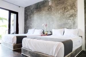 two beds in a room with a wall at Lunazul Hotel By Rotamundos in La Vigueta