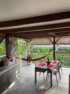 a kitchen with a table and a hammock on a balcony at La Fée amazonienne in Rivière-Pilote