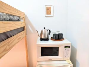 - un four micro-ondes avec une bouilloire à côté d'un lit dans l'établissement The VILLAGE HOUSE NYC, à New York