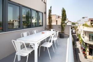 a white table and chairs on the balcony of a building at Downtown Athens Lofts - The Acropolis Observatory in Athens