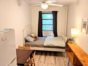 - une petite chambre avec un lit et une fenêtre dans l'établissement The VILLAGE HOUSE NYC, à New York