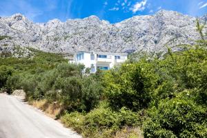 a white house on the side of a road with mountains at Maestral in Veliko Brdo