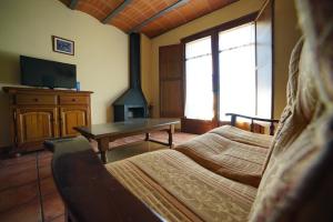 a room with two beds and a table and a fireplace at Gra de fajol in Girona