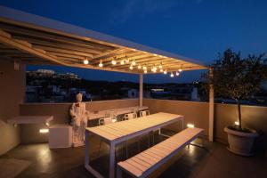 a rooftop deck with a table and bench and lights at Downtown Athens Lofts - The Acropolis Observatory in Athens
