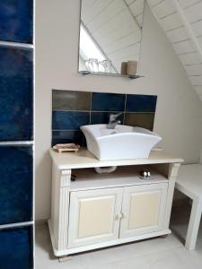 baño con lavabo blanco y azulejos azules en Alba-Ház apartman, en Zalakaros