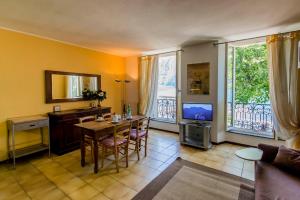 a living room with a table and a television at Le Residenze Del Conte Agudio in Malgrate