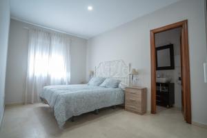 a bedroom with a bed and a mirror and a window at Las Palomas 15 in Sanlúcar de Barrameda +41 photos