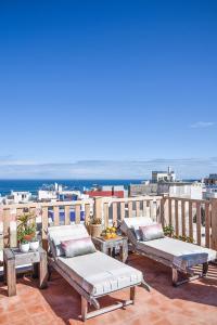 - un balcon avec 2 lits et une vue sur l'océan dans l'établissement Riad Lyon-Mogador, à Essaouira