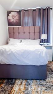 a bedroom with a large bed with a pink headboard at Room in Guest room - Newly Built Private Ensuite In Dudley Westmidlands in Dudley