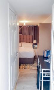 a bedroom with a bed and a desk and a door at Room in Guest room - Newly Built Private Ensuite In Dudley Westmidlands in Dudley
