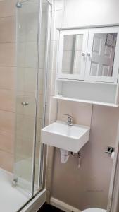 y baño blanco con lavabo y ducha. en Room in Guest room - Newly Built Private Ensuite In Dudley Westmidlands en Dudley
