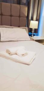 a white bed with two napkins on top of it at Room in Guest room - Newly Built Private Ensuite In Dudley Westmidlands in Dudley