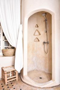a bathroom with a shower with a shower curtain at Riad Lyon-Mogador in Essaouira