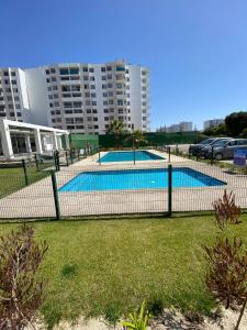 a fence around a swimming pool in a city at La Serena Costa in La Serena