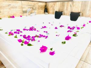 Una mesa blanca con flores rosas. en Ale Park Hotel Apartments, en Antalya