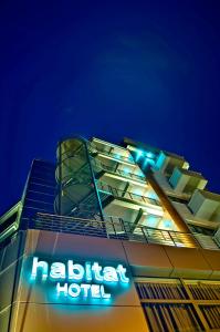 a hotel with a sign on top of it at night at Habitat Hotel in Kilkis