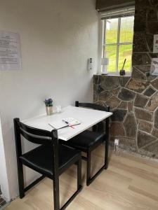 ein weißer Tisch und zwei Stühle in einem Zimmer in der Unterkunft Gróthusið in Sørvágur + 24 Fotos