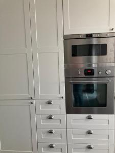 een keuken met witte kasten en een oven bij Casa diatomea in De Haan