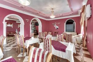 ロストフ・ナ・ドヌにあるGrieg Hotelのピンクの壁のレストラン