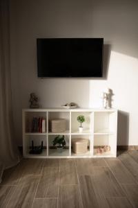 una mensola bianca con TV a schermo piatto a parete di Irida's sea front apartment with astonishing view a Theológos