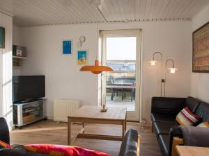 a living room with a couch and a table at Holiday home Fanø LXXXVI in Fanø