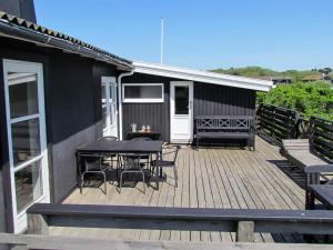 a deck with a table and chairs on a house at Holiday home Fanø LXXXVI in Fanø