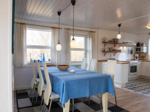 a dining room with a blue table and chairs at Holiday home Fanø LXXXVI in Fanø