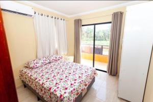 une chambre avec un lit et une grande fenêtre dans l'établissement Casa Maré Mansa na Praia de Peroba, Maragogi, à Maragogi