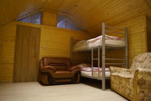 a room with a bunk bed and a chair and a couch at Gemütliches Haus mit Sauna im Voralpenland in Peißenberg