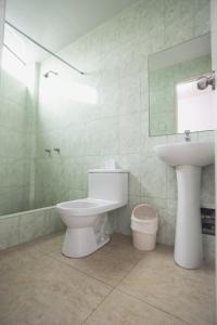 ein Badezimmer mit einem WC, einem Waschbecken und einem Spiegel in der Unterkunft Hostal Sueños Breña in Lima