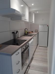 a kitchen with white appliances and a white refrigerator at Appartement Grabels 2 à 4 personnes in Grabels