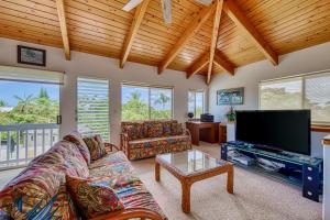 a living room with a couch and a flat screen tv at Kona Kanewa Home in Kailua-Kona