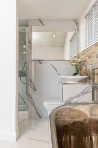 uma casa de banho com um lavatório e um espelho em Relax in Super Size Copper Tub - 2 bedroom villa em Inverness