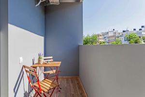 a table and chairs in a room with a blue wall at Raise Heraklion Boutique Apartments in Heraklio Town