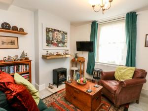 ein Wohnzimmer mit Couch und Kamin in der Unterkunft Harbour Catch Cottage in Weymouth