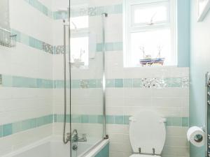 ein Badezimmer mit Badewanne, Toilette und Dusche in der Unterkunft Harbour Catch Cottage in Weymouth + 10 Fotos