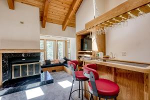 cocina con barra con sillas rojas y chimenea en Marshall Retreat en South Lake Tahoe