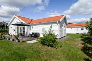 a white house with a patio and an umbrella at Great Stay Villa Sandviken in Sandviken