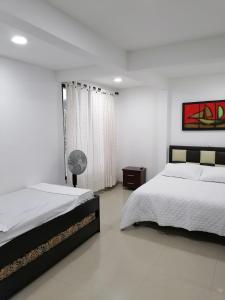 1 dormitorio blanco con 2 camas y ventana en Apartamento Campestre Pereira, en Pereira