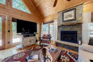 a living room with a fireplace and a flat screen tv at ANIA's Cabin in Talking Rock
