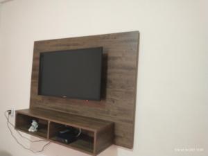 uma televisão de ecrã plano numa parede de madeira em suites montanha das letras em São Tomé das Letras