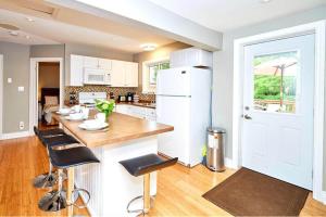 a kitchen with a counter and a white refrigerator at Maple Tree Cottage License # 058-2022 in Niagara on the Lake